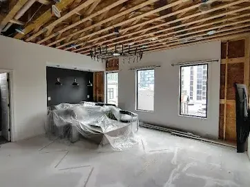 A ceiling opened up for drying above furniture protected under plastic sheeting